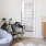 comfy chair next to bright window and bathroom entrance in large bedroom