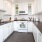 a kitchen with white cabinets and subway tiled backsplash